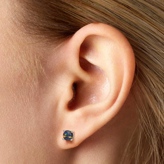 model featuring round black opal stud earrings