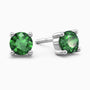 Sterling silver stud earrings featuring round-cut emeralds, displayed on a dark background.